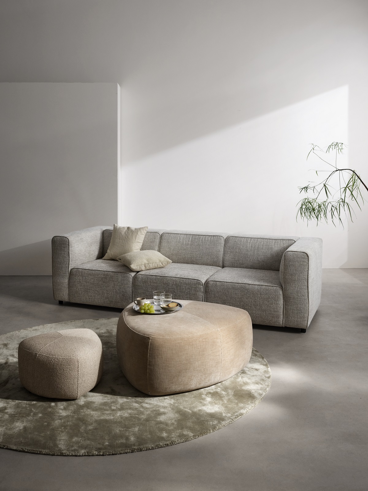 roomset with cream couch and 2 bermuda pebble shaped footstools