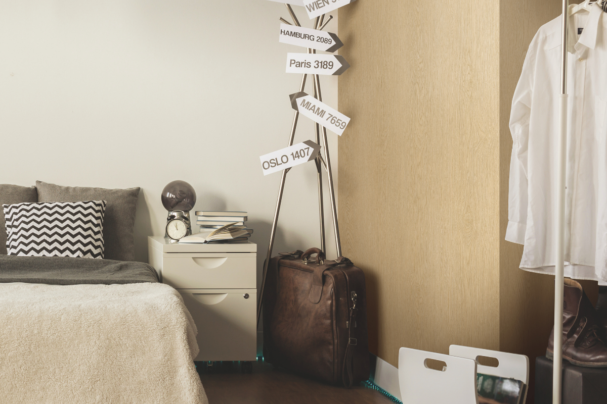 Close up shot of hotel room with architectural film wall. Decor includes signage to several global destinations and a vintage suitcase