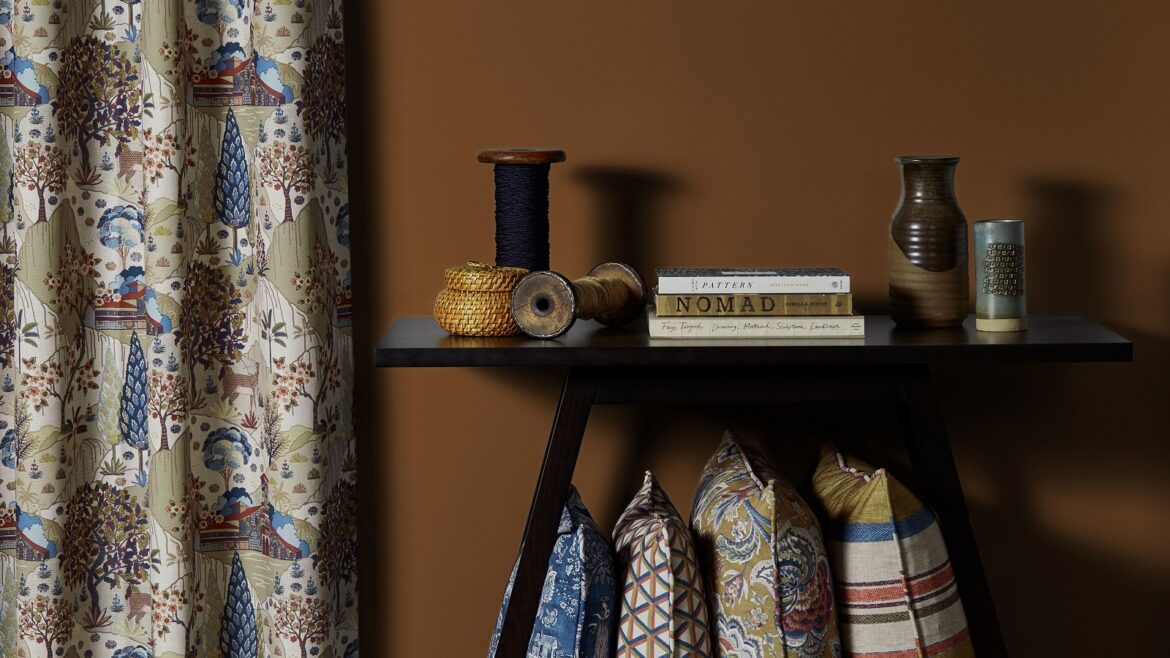 table with books and vases with curtains and cushions in fabric from Edmund Bell