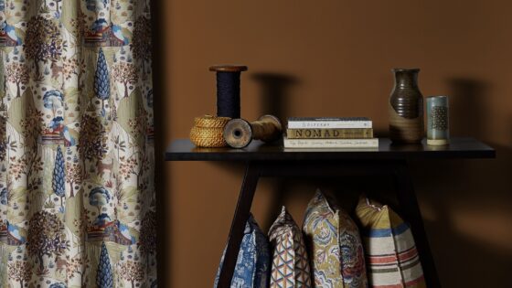 table with books and vases with curtains and cushions in fabric from Edmund Bell