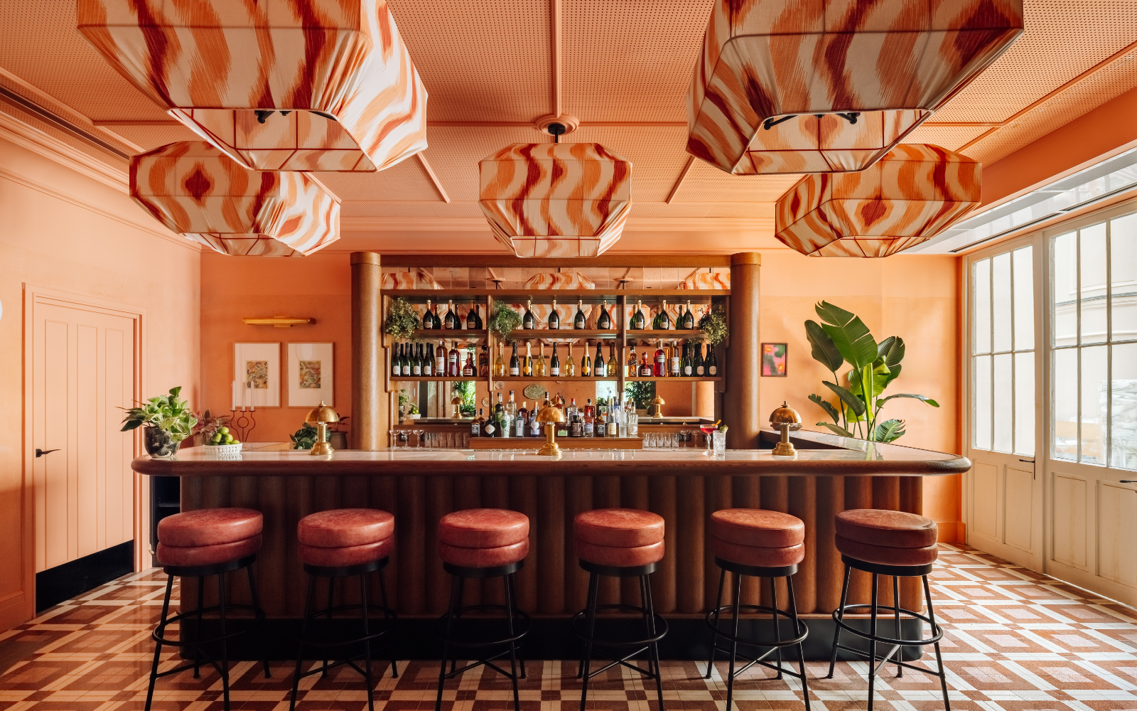 Orange bar area at Le Jardin de Verre, with several fabric pendants hanging from ceiling
