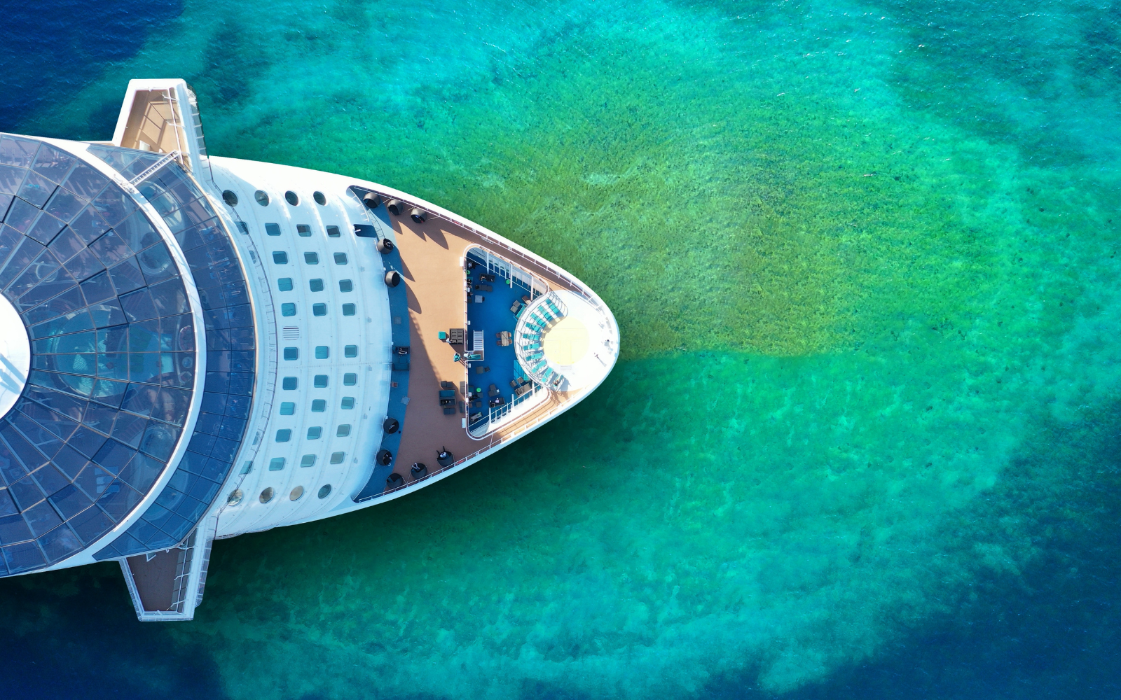 Birds-eye-view of cruise ship on turquoise green sea