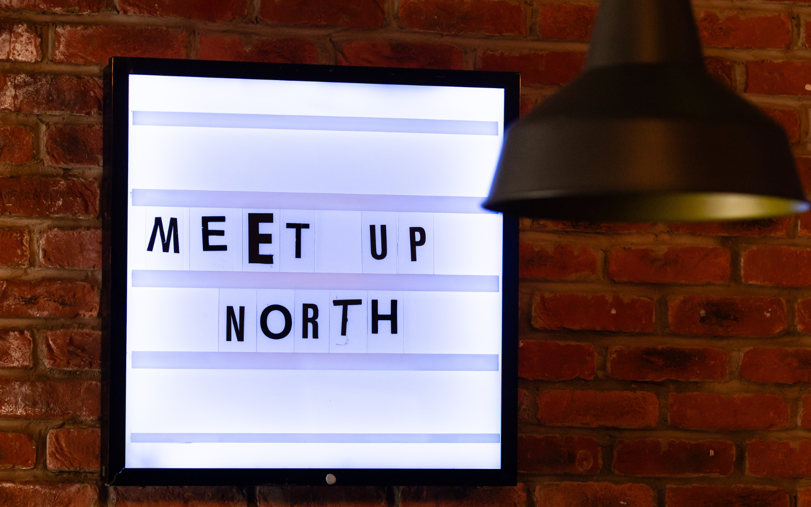 MEET UP North text in cut out newspaper style font on light box