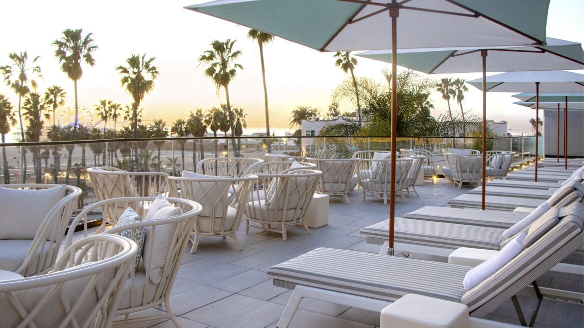 palm trees and umbrellas on the terrace at sunset at Regent Santa Monica Beach