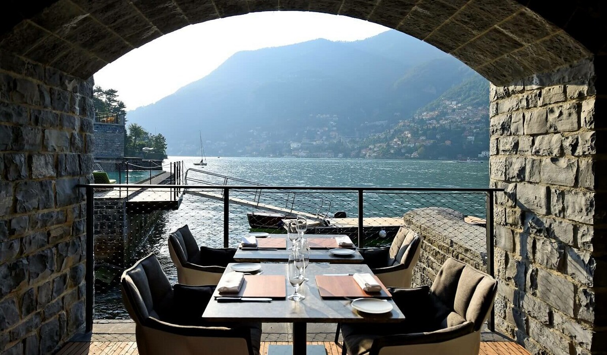stone arch with dining table with view across lake como