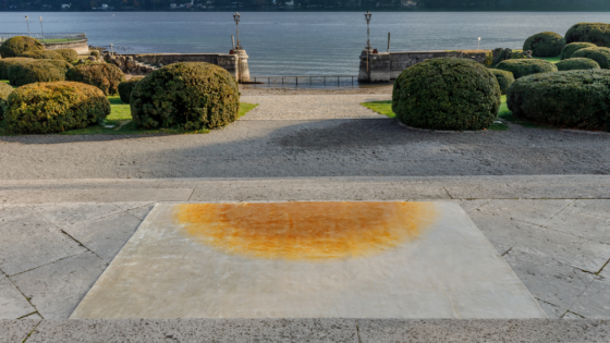 carpet with cream and orange abstract design on paving next to a lake