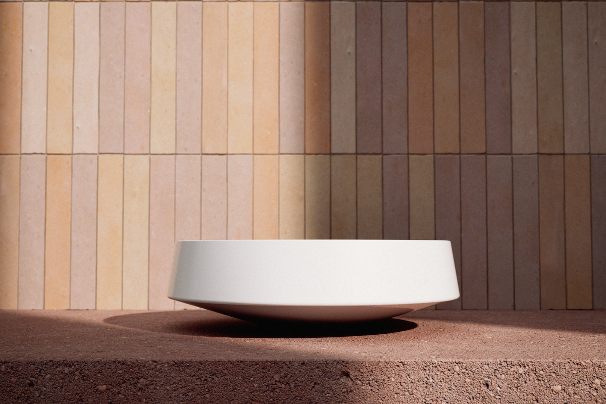 White Nib washbasin design from Alape, set on terracotta stone with warm toned tiled backdrop