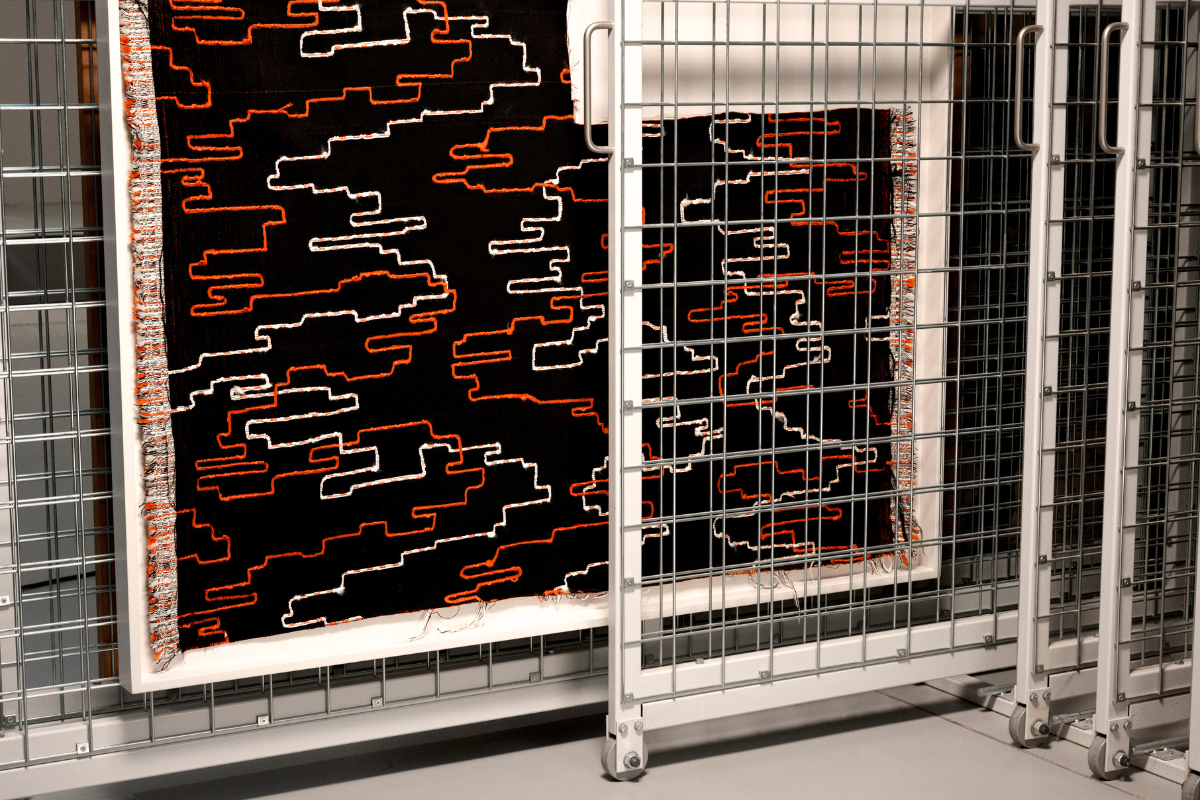 Black, white and red woven fabric on metal fencing