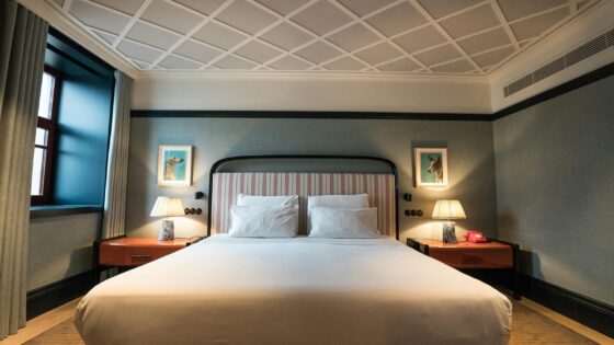 double bed in hotel guestroom with bed side lights lit up on either side