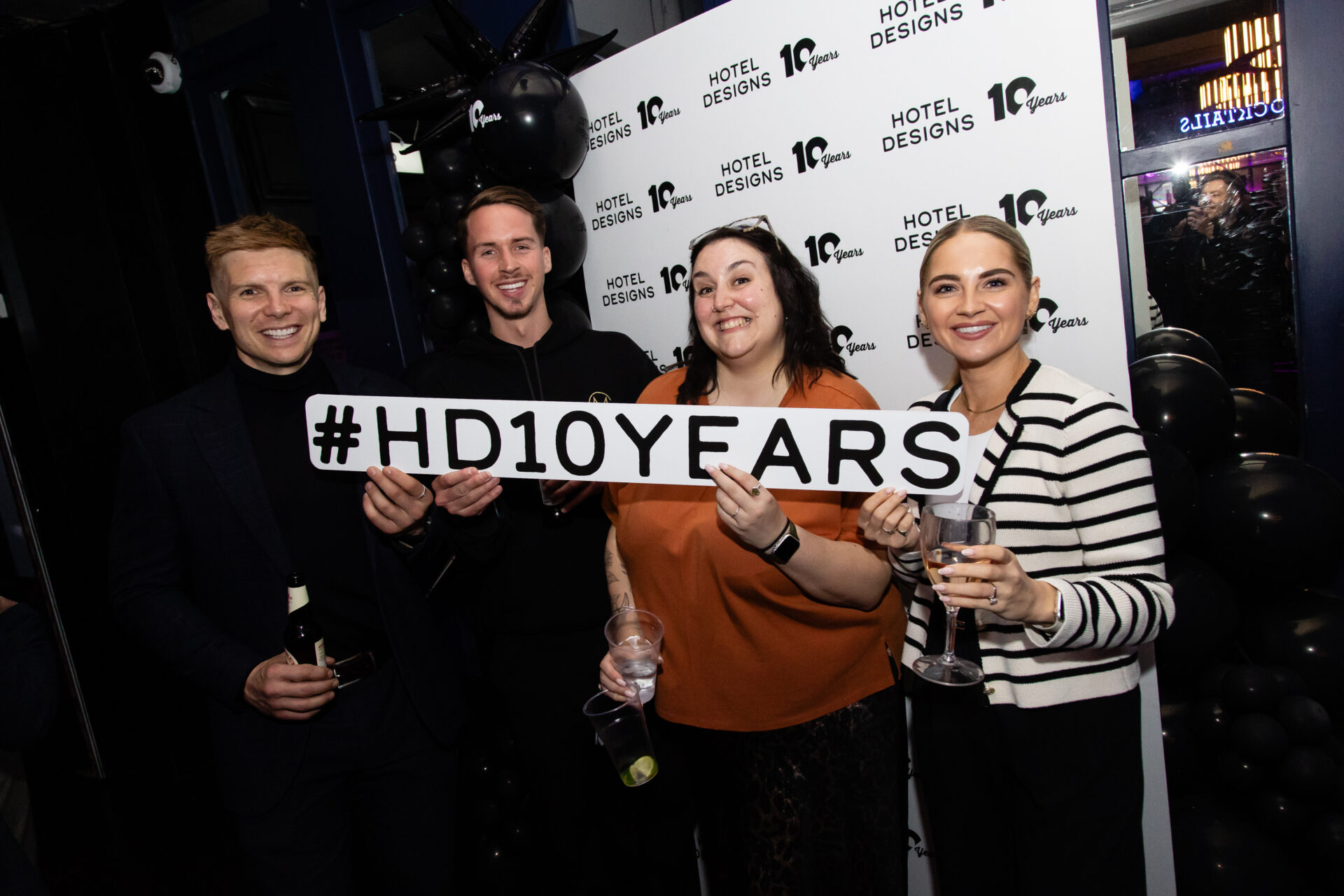 4 MEET UP London guests holding the #HD10YEARS Board