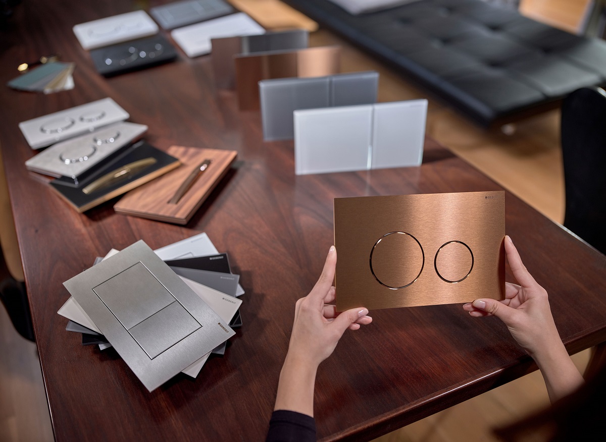 a selection of samples , colours and finishes of Geberit flush plates on a table