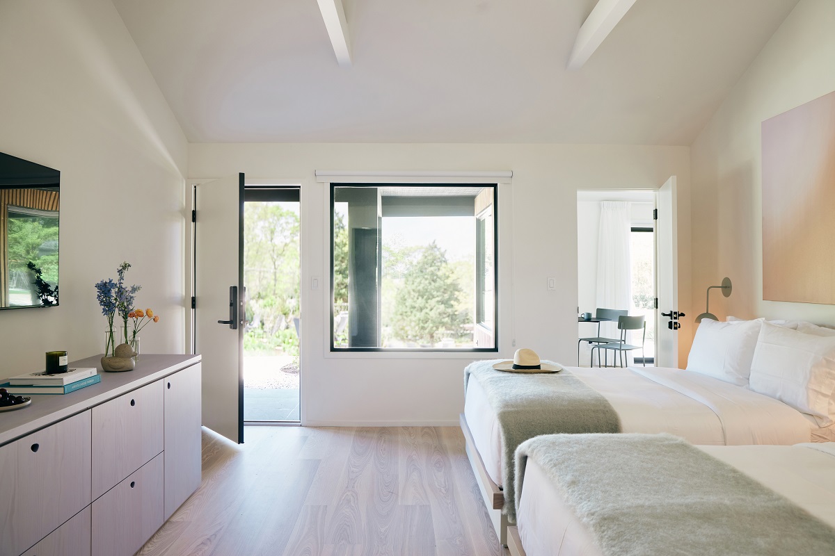 white floor and white beamed ceiling in guestroom with 2 beds in Three Ducks Hotel