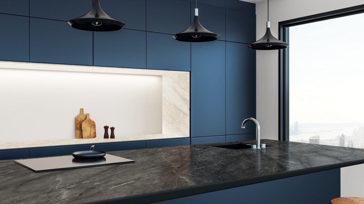 dark blue wall, grey work surface and stone coloured shelf in kitchen with Merinolam from James Latham