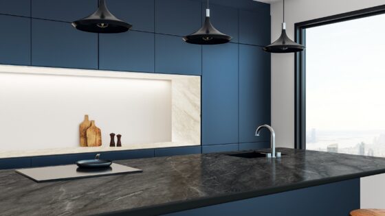 dark blue wall, grey work surface and stone coloured shelf in kitchen with Merinolam from James Latham