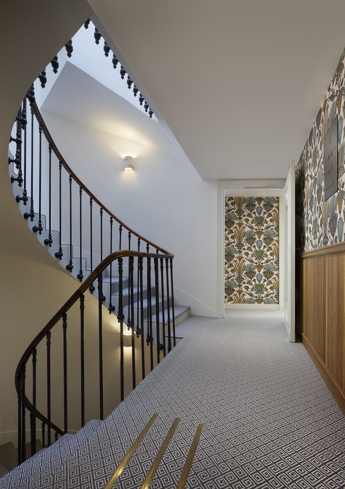 curved period stairwell with panels of wallpaper