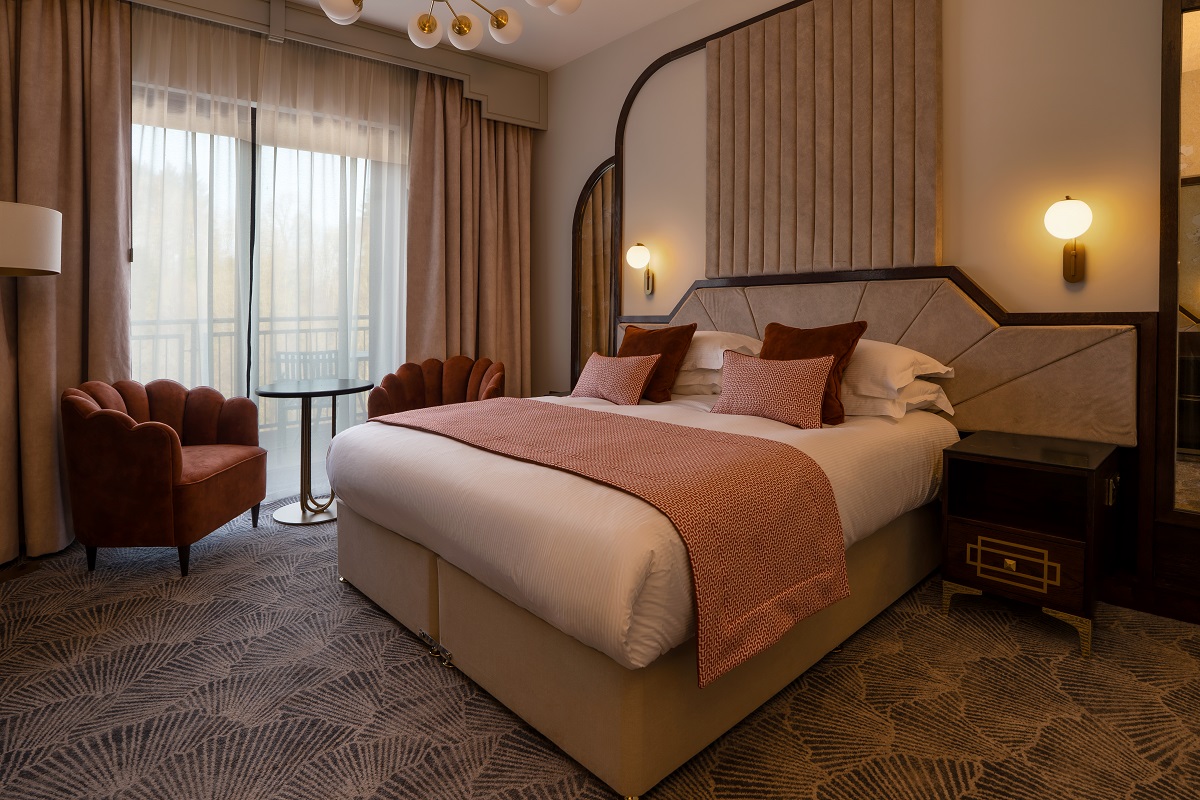 curved headboard and art deco shell shaped chairs in the hotel guestroom