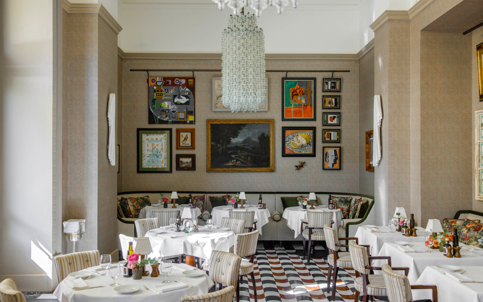 Restaurant space at Hotel Savoy, with brightly coloured gallery wall and large glass chandelier