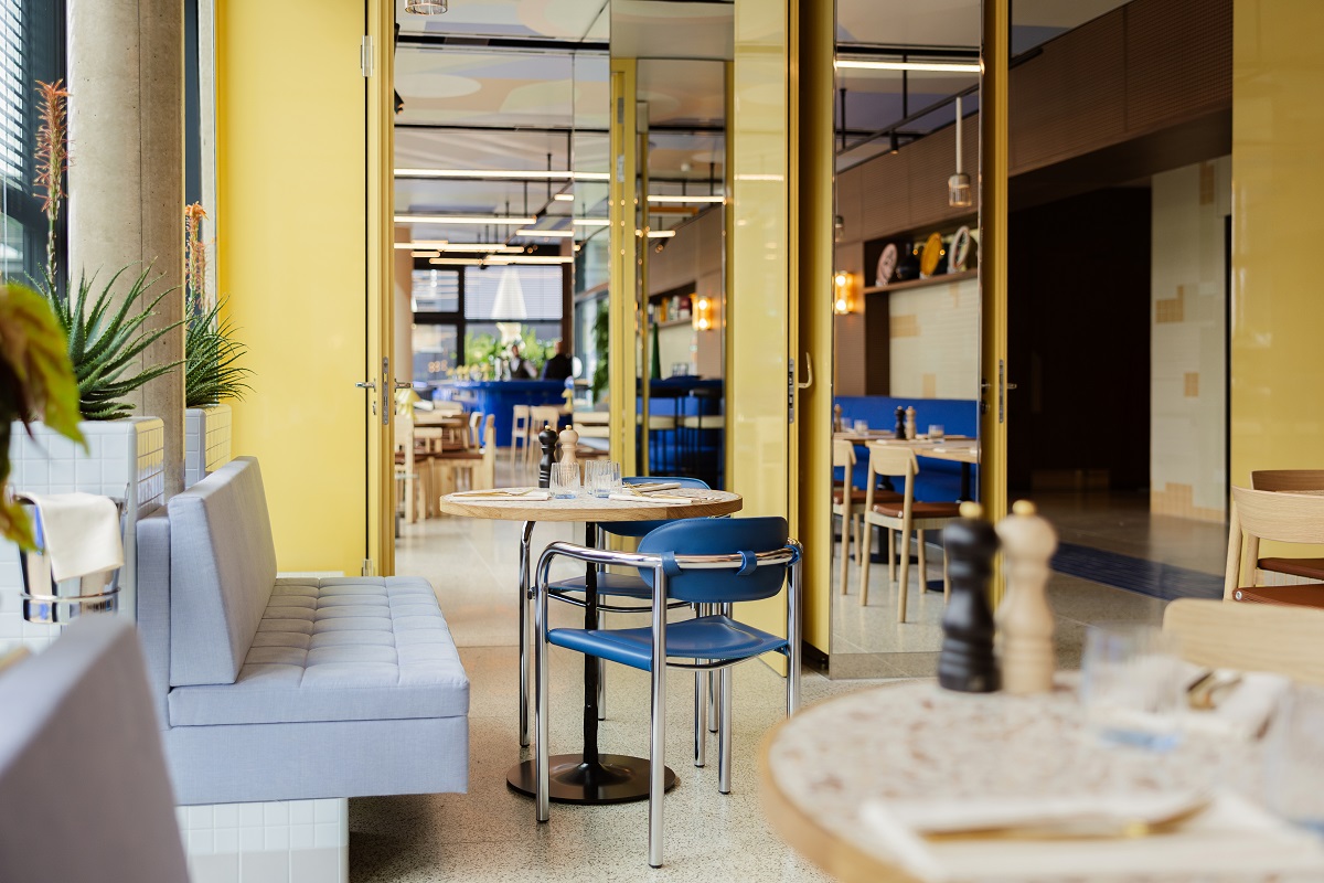 yellow walls and blue furniture in hotel restaurant in Kimpton Main Frankfurt