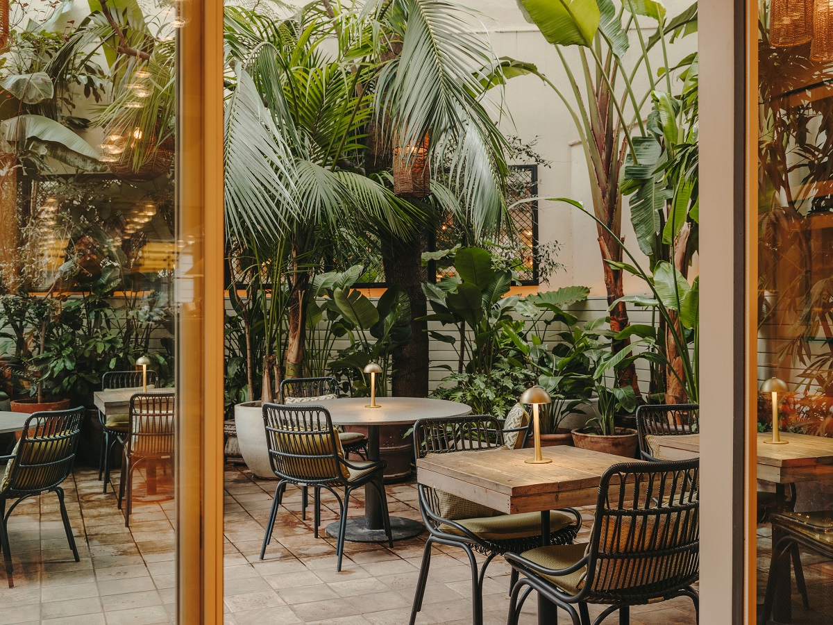 tables, chairs, plants in interior courtyard hotel Pulitzer Barcelona