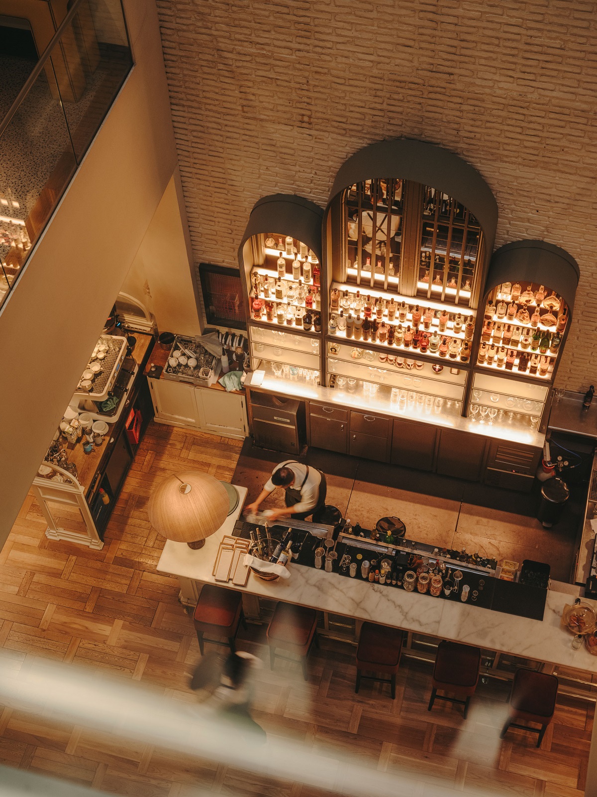 looking down from the lift onto the bar in the lobby of Pulitzer Barcelona