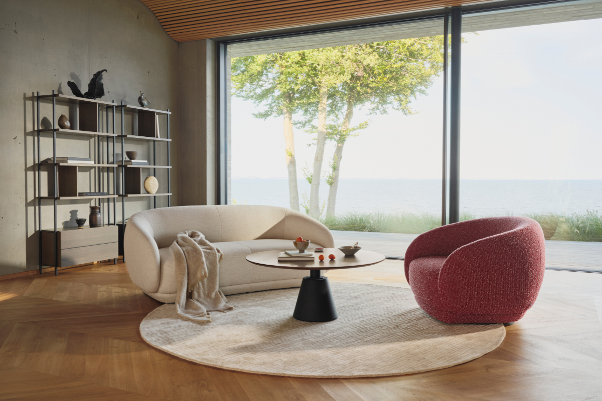 BoConcept Trade & Contract Bolzano lounge chairs in bright lounge area with wooden floors and large glass sliding doors overlooking sea view