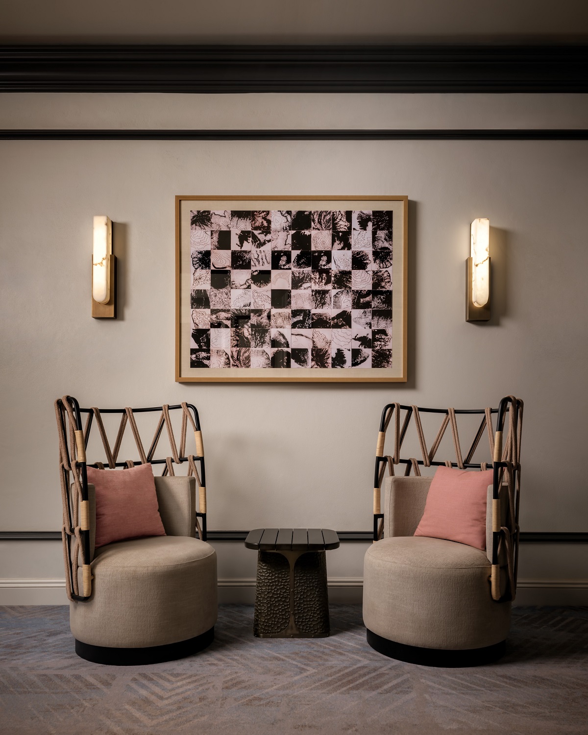 two wicker chairs in front of art and lights