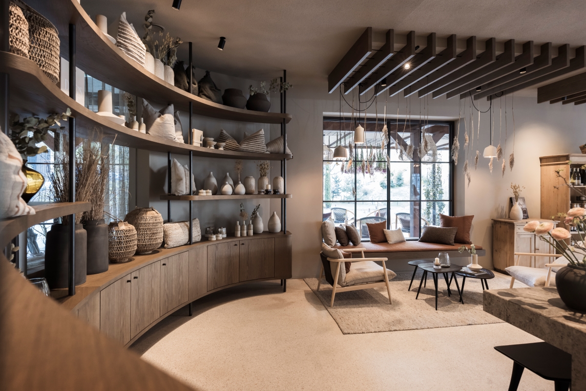 Curved wall of The Barn by NOA lined with shelving and unique objects
