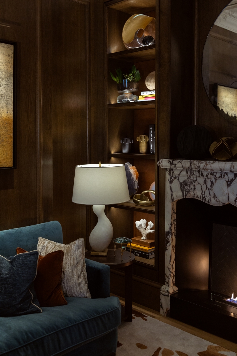 The Snug in the Heritage Bar at the Corinthia Bucharest, with teal sofa, marble fireplace and white organic lamp