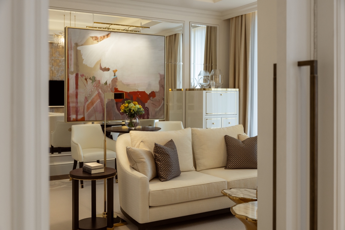 Superior Suite lounge area at the Corinthia Bucharest, gold frames paintings on back wall while cream sofas sit in front