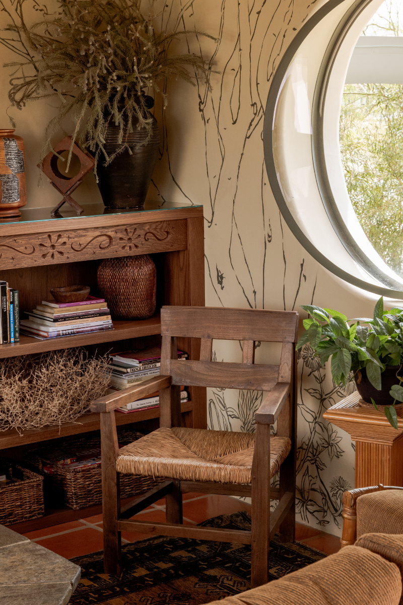 Close up shot of wooden chair and wall mural with bookshelf in Manola Studio designed Hotel Wren