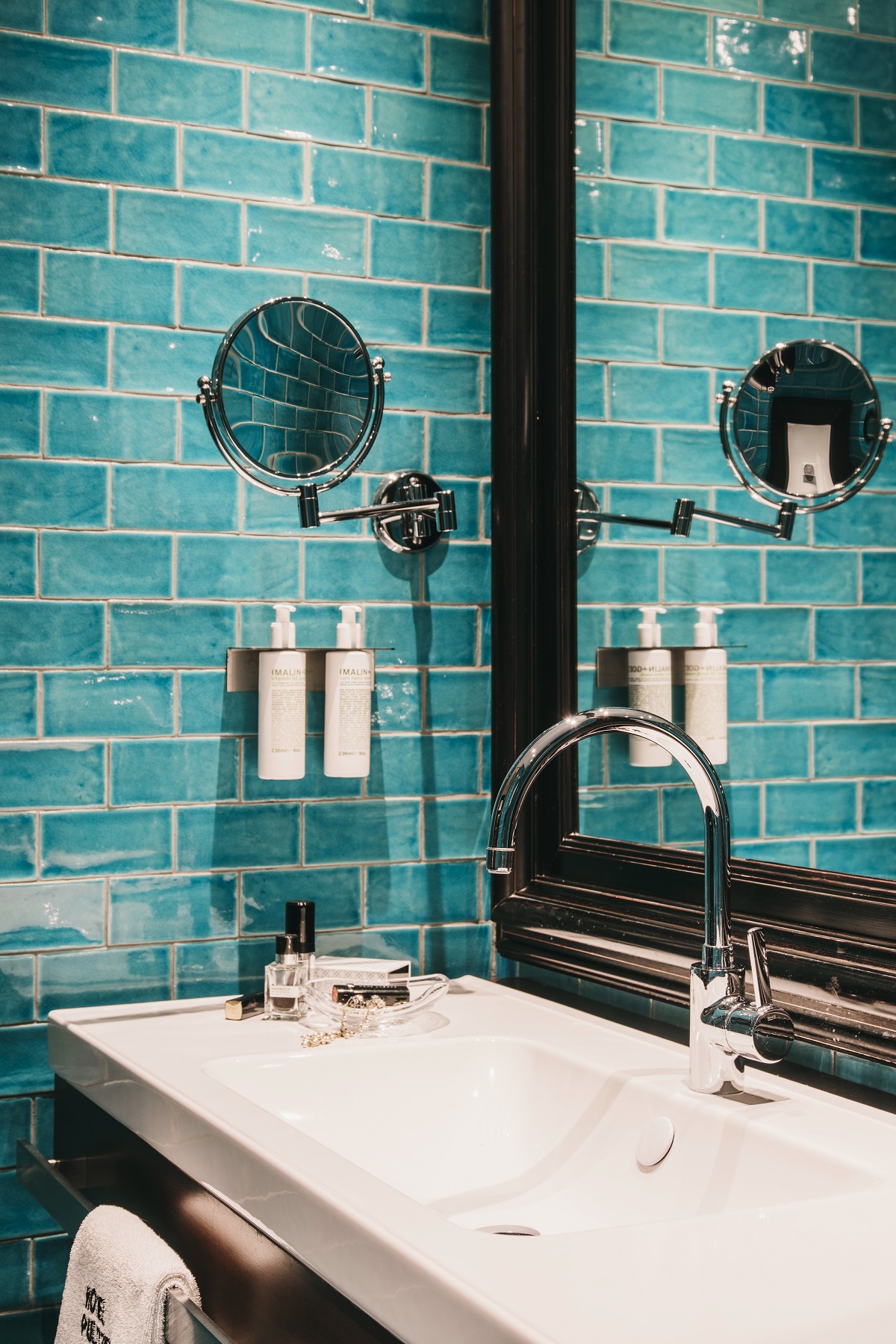 turquoise tiled bathroom with oversized wooden mirror frame