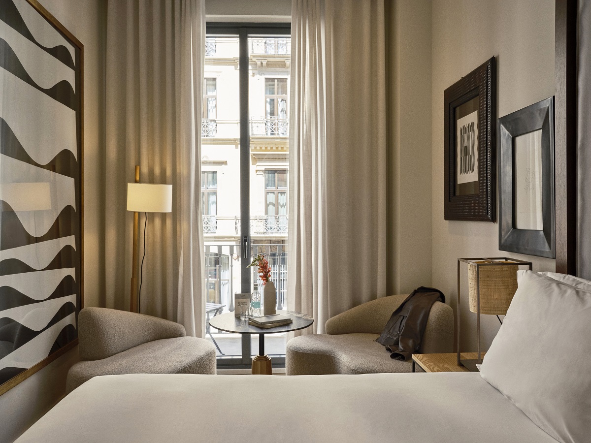 guestroom in Hotel Pulitzer Barcelona with brown framed art and city balcony