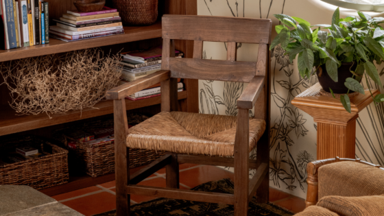 Close up shot of wooden chair and wall mural with bookshelf in Manola Studio designed Hotel Wren