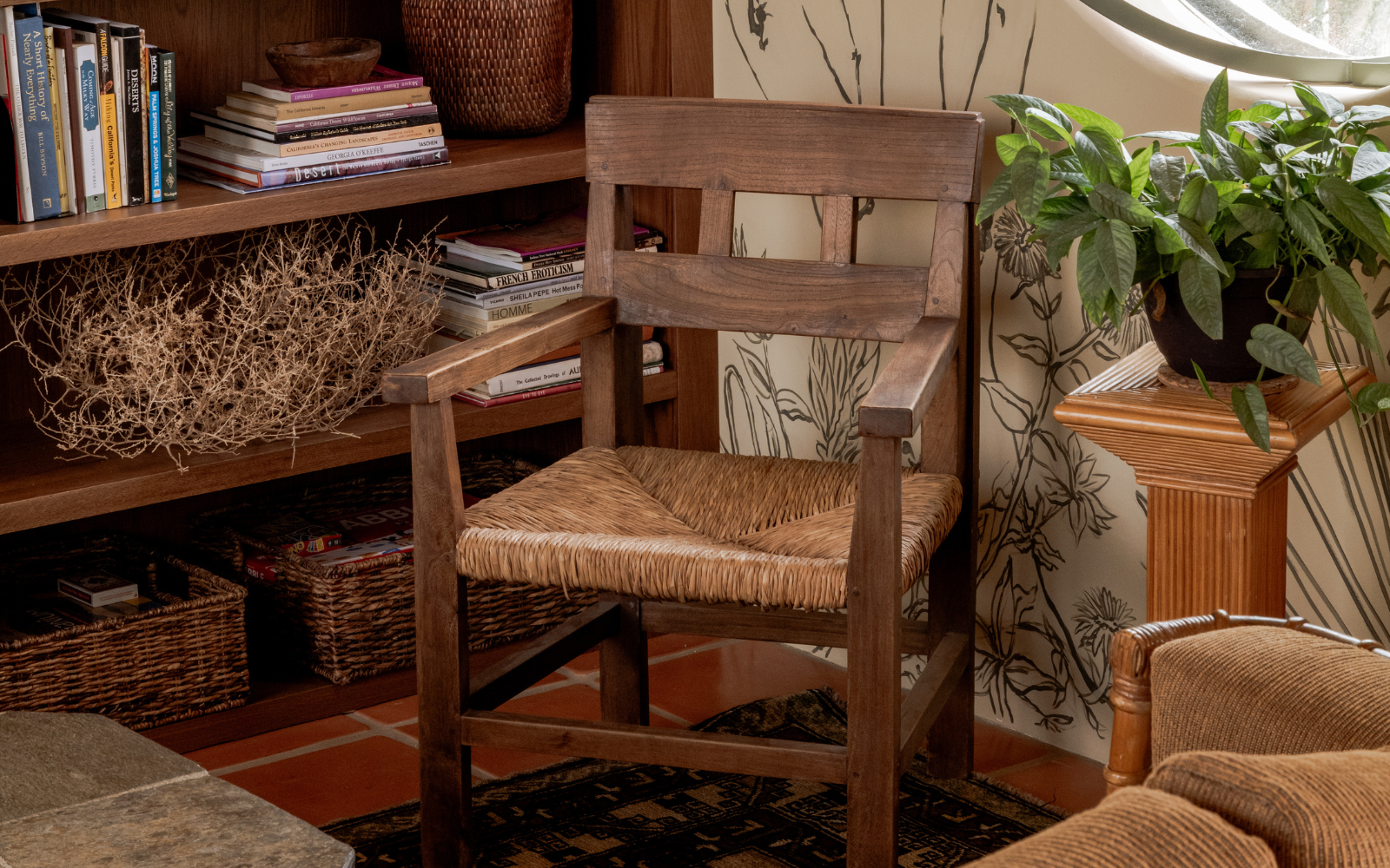 Close up shot of wooden chair and wall mural with bookshelf in Manola Studio designed Hotel Wren