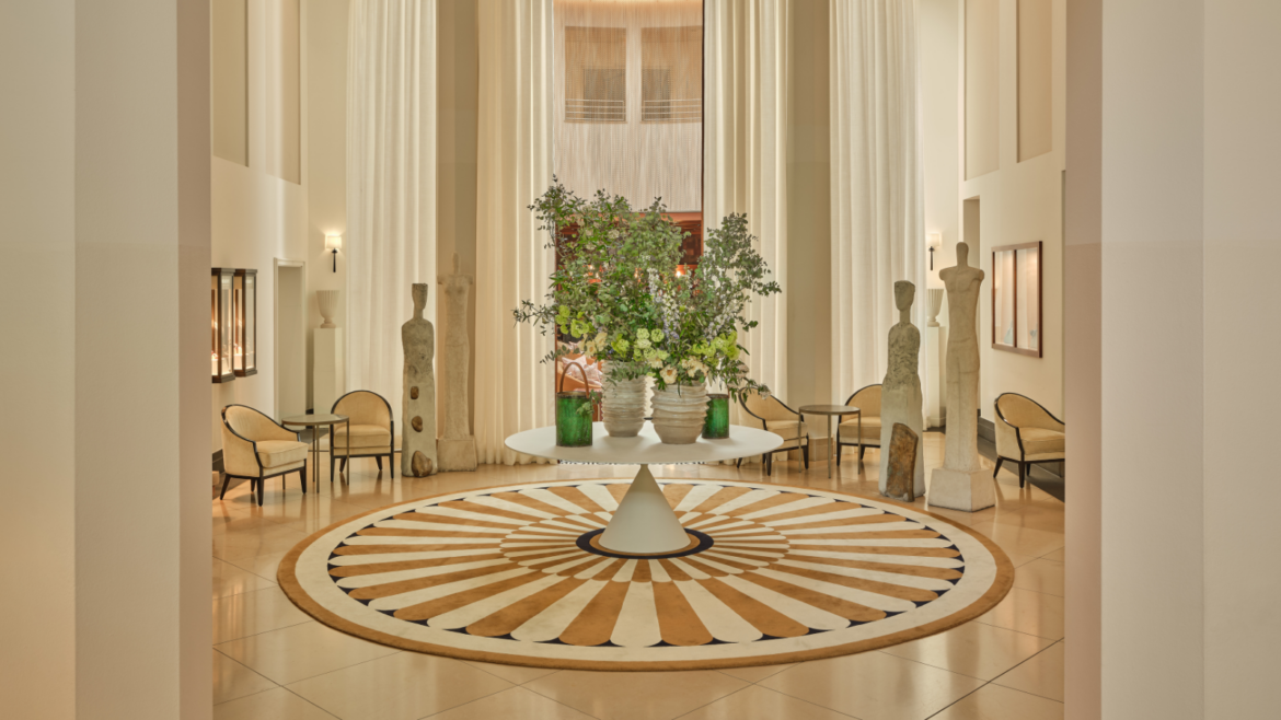 Lobby of The Charles Rocco Forte Hotel, with central table with floral arrangement and intricate circular pattern floor