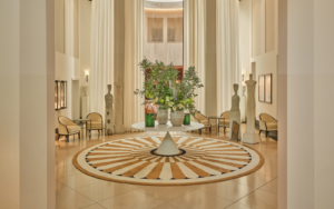Lobby of The Charles Rocco Forte Hotel, with central table with floral arrangement and intricate circular pattern floor