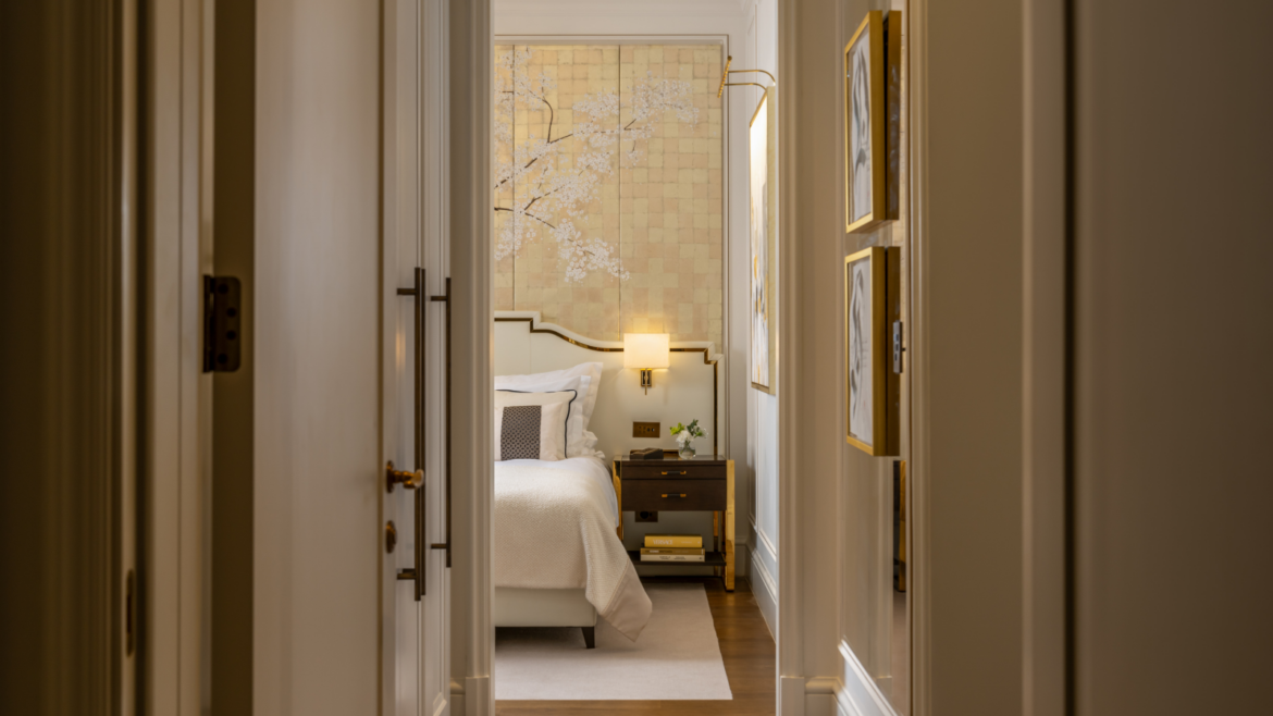 Shot of bedroom at Corinthia Grand Hotel Bucharest, designed by GA Group. Far wall shows gold print with white cherry blossom flowers covering.