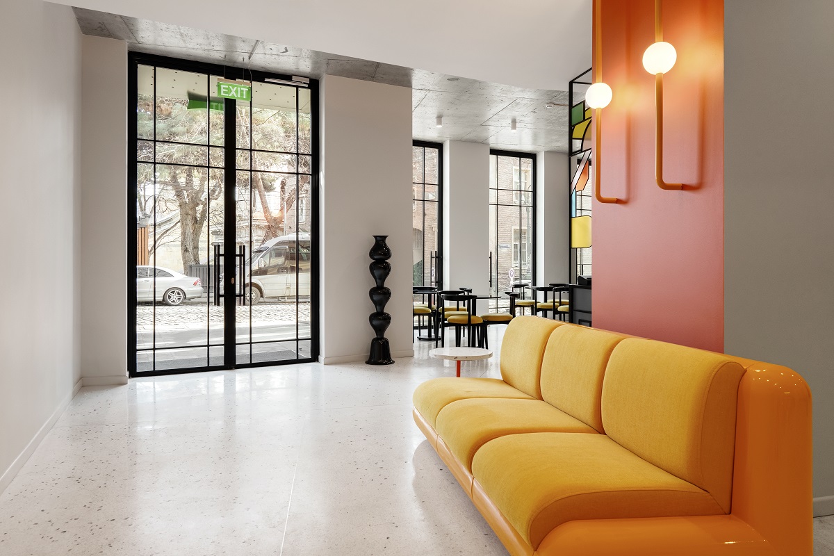 bright yellow couch on white floor in hotel entrance