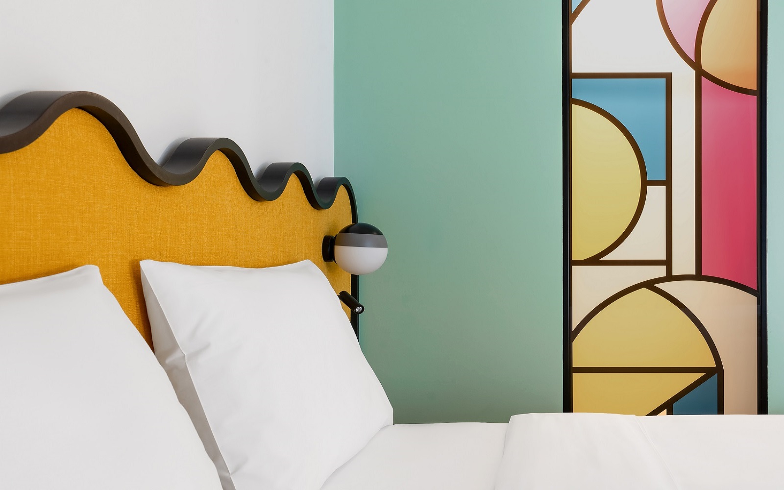 yellow wavy headboard detail and painted mural in guestroom by Studio Shoo in ibis Tiblisi