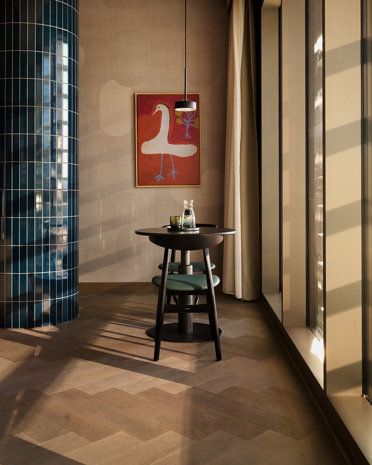 wooden floor, blue tiles wall, wooden table in front of art on the wall