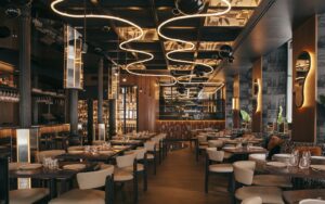 curved statement lighting on ceiling above seating and mirrored surfaces in Astet Roostiq bar and restaurant