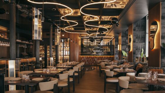 curved statement lighting on ceiling above seating and mirrored surfaces in Astet Roostiq bar and restaurant