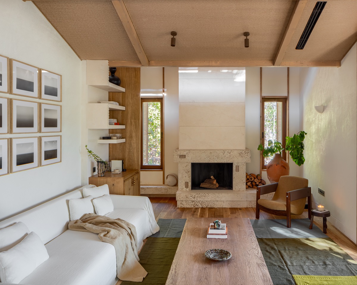 interior of holiday beach cabin with white couch, wooden table and fireplace