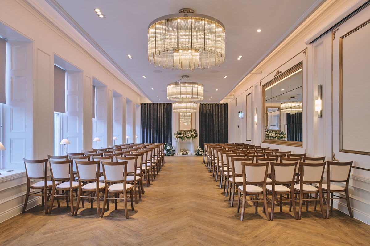 A light and bright events space with statement chandeliers in the centre of the ceiling. The guest is guided through the room by chevron patterned flooring.