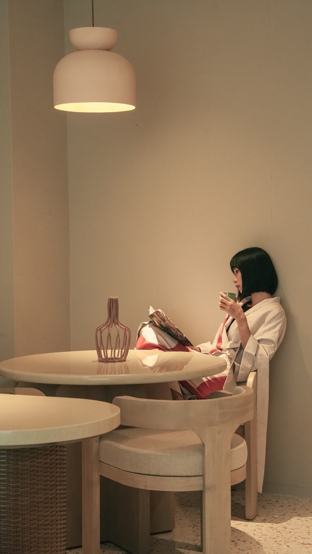 woman sitting at round table reading a book