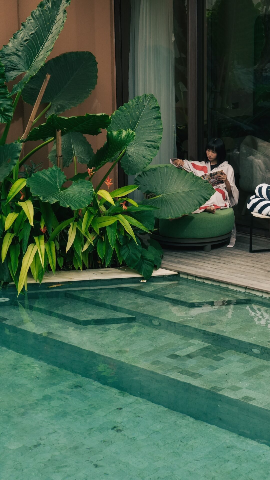 relaxing in courtyard at Noem in Bali with tropical plants and courtyard pool
