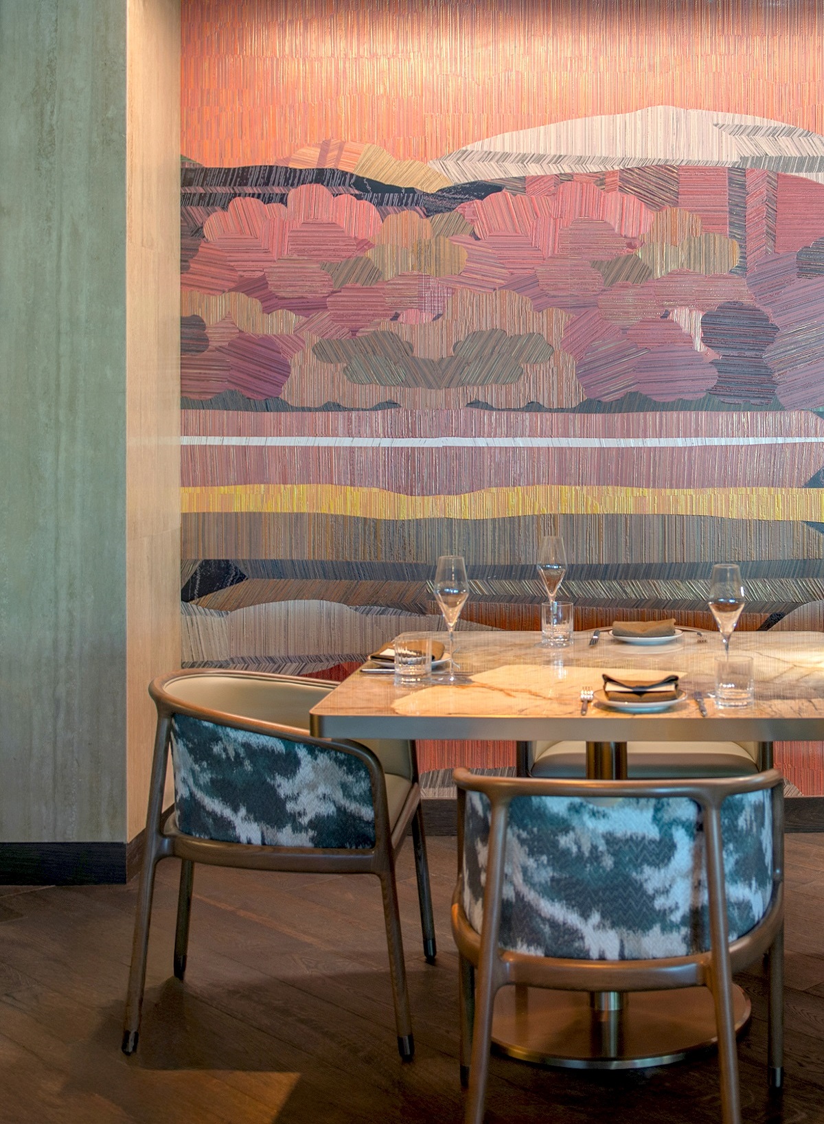 table setting in restaurant in front of mountain inspired mural on the wall