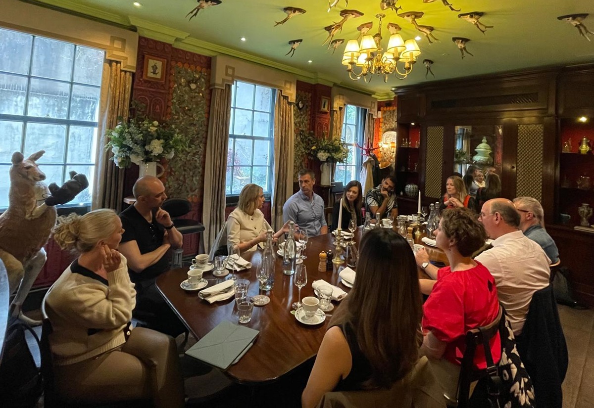 A roundtable conversation with a point being made by Caitriona McGachy while all the other attendees look at her, listening intently.