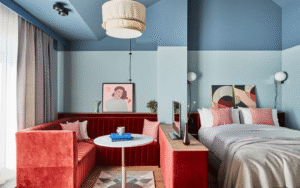 Pale blue walled room at Locke Munich with rust coloured seating area