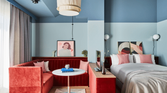 Pale blue walled room at Locke Munich with rust coloured seating area